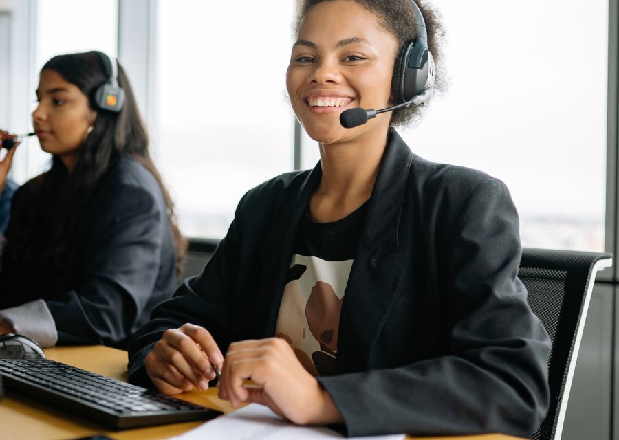 Conseillère du service client avec casque, souriante à son poste